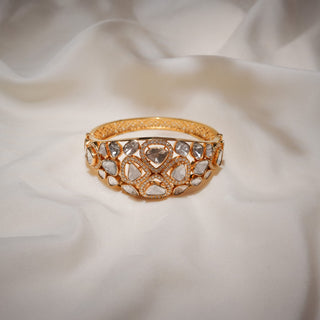 yellow gold lab grown diamond polki ring placed on an off-white silk cloth