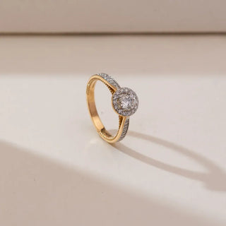 yellow gold solitaire lab grown diamond engagement ring placed with a cream colored background