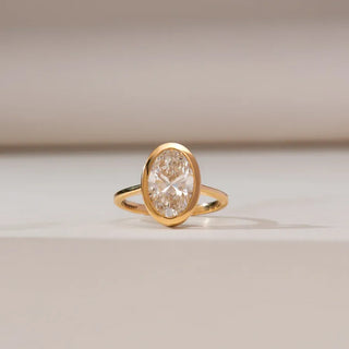 yellow gold lab grown diamond engagement ring placed with a beige background