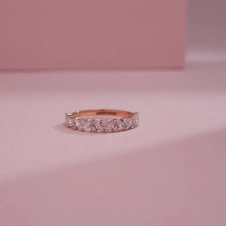 rose gold lab grown diamond half eternity band placed with a light pink background