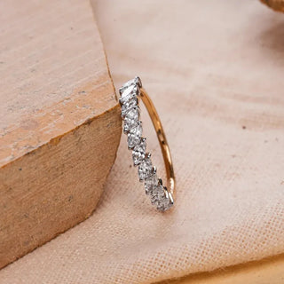 yellow gold lab grown diamond wedding band placed against a wooden corner on a cream colored cloth