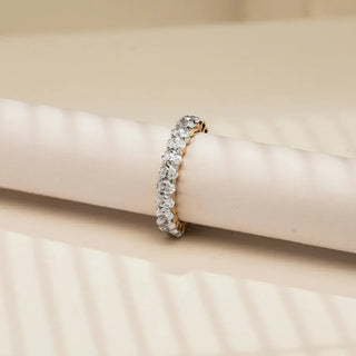 yellow gold lab grown diamond full eternity band placed with an off white colored sheet with an off white background
