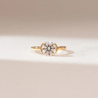 yellow gold solitaire lab grown diamond engagement ring placed with an off-white background