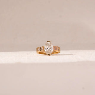 yellow gold lab grown diamond engagement ring placed with an off-white background