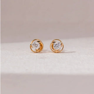 yellow gold lab grown diamond earrings placed with an off-white background