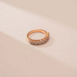 yellow gold lab grown diamond half eternity band placed on an off-white surface