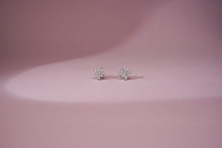 Réia lab-grown diamond stud earrings with floral cluster design, displayed on a soft pink background for timeless elegance.