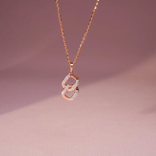 rose gold lab-grown diamond pendant placed with a light pink background