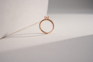 lab-grown diamond ring with a rose gold band with a white and grey background 