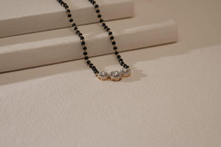 lab-grown diamond mangalsutra placed on a beige coloured cardboard with a light beige background