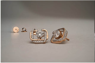 Rose gold geometric stud earrings featuring a floating solitaire lab-grown diamond surrounded by a pavé frame, on a light grey surface.