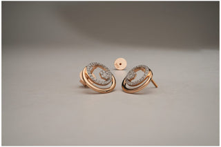 Rose gold stud earrings with a double oval design and a pavé cluster of lab-grown diamonds, shown with the back piece on a grey surface.