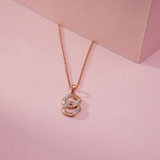 lab-grown diamond pendant necklace kept under a light pink cardboard with a light pink background 