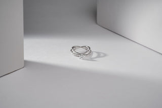 lab-grown diamond ring with a white gold band placed between two white cardboards with a white and grey background