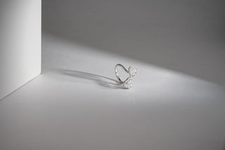 lab-grown diamond ring placed close to a light white cardboard with a light grey and white background 