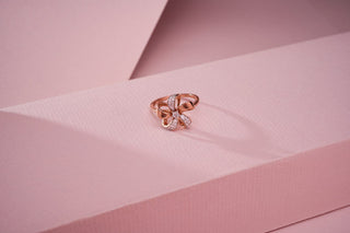 rose gold lab-grown diamond ring placed on a light pink surface with a light pink background