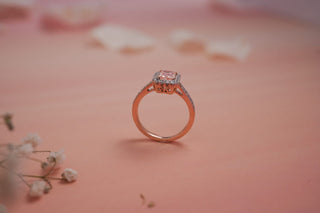 pink coloured lab-grown diamond engagement ring with a rose gold band placed amidst flower petals with a light pink background