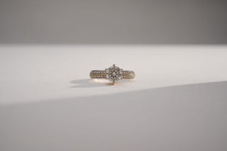 yellow gold lab-grown diamond engagement ring placed with a white and grey background