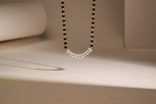 lab-grown diamond mangalsutra placed in the center of the frame with a beige background