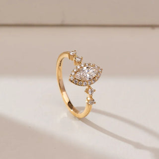 yellow gold marquise cut lab grown diamond engagement ring placed with an off white background