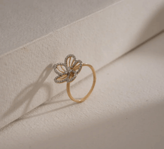 yellow gold lab grown diamond designer ring placed leaning on a beige surface with a beige background