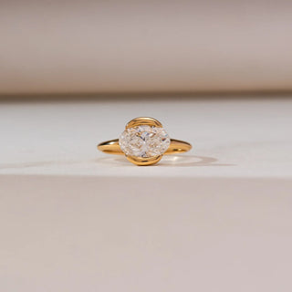yellow gold solitaire lab grown diamond engagement ring placed with a cream coloured background