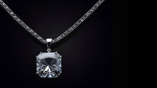 An elegant emerald-cut lab-grown diamond solitaire pendant necklace from Réia Diamonds, set against a dark background.