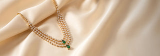 Side view of a three-row lab-grown diamond necklace in 14 KT yellow gold, featuring cascading pear-shaped diamonds accented with emerald-green pear-cut gemstones in a luxurious statement design.