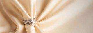 Réia yellow gold solitaire ring with a twisted lab-grown diamond band, resting on beige fabric.