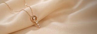Close-up of a woman wearing a rose gold necklace with a spiral lab-grown diamond pendant and a matching ring.