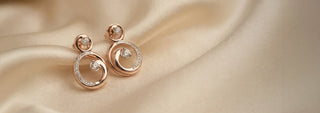 Close-up of a woman wearing a rose gold necklace with a spiral lab-grown diamond pendant and a matching ring.