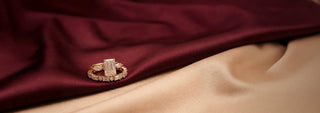 A Réia white gold ring, featuring a round lab-grown diamond and diamond-set band, is worn on a hand resting on a knee