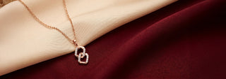 Top view of a lab-grown diamond link pendant in 14 KT rose gold, featuring interlocking open oval links with pavé-set diamond accents and a delicate matching chain.