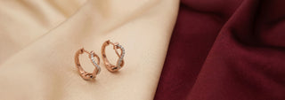 Réia pair of white gold hoop earrings with channel-set lab-grown diamonds, displayed on beige fabric.