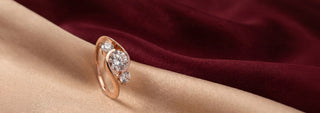 A Reia rose gold engagement ring with a large marquise lab-grown diamond, flanked by small round and marquise diamonds, set in a velvet ring box.
