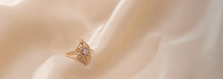 Réia rose gold flower-shaped ring with lab-grown diamonds, resting on satin fabric.