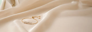 Front view of Diamond Adjustable Bracelet in 14KT Yellow Gold, featuring marquise and round diamonds arranged in a leaf-inspired motif with a sliding clasp. Captured against a beige backdrop, the delicate design radiates elegant sparkle.