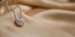 Réia white gold heart-shaped diamond pendant necklace with lab-grown diamonds on satin fabric.