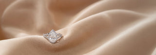 Reia white gold eternity band featuring large, round lab-grown diamonds in a prong setting, resting on a beige fabric.