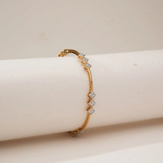 Side view of Geometric Rhombus Trio Diamond Bangle in yellow gold, featuring pavé-set round lab-grown diamonds in rhombus motifs along a sleek, structured band, displayed on a neutral form.