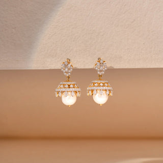 Close up view of pearl and  pear shaped lab-grown diamond jhumka earrings in 14 KT white gold, featuring floral diamond studs, pavé-set dome motifs, marquise-cut diamond accents and lustrous pearl drops in a traditional design.