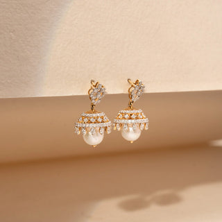 Side view of pearl and lab-grown pear shaped  diamond jhumka earrings in 14 KT rose gold, featuring floral diamond studs, pavé-set dome motifs, marquise-cut diamond accents and lustrous pearl drops in a traditional design.