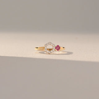 Front view of Hexagon Diamond Open Ring in 14KT Yellow Gold, featuring lab grown diamonds in a hexagon halo with a pink gemstone cluster accent. Set on a beige backdrop, the design highlights contrast and modern elegance.
