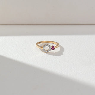 Top view of Hexagon Diamond Open Ring in 14KT Yellow Gold, featuring lab grown diamonds in a hexagon halo with a pink gemstone cluster accent. Set on a beige backdrop, the design highlights clean lines and contrast.
