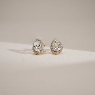 Front view of oval-cut lab-grown diamond halo stud earrings in 18KT Yellow Gold, featuring EF-VVS diamonds surrounded by a brilliant halo, displayed on a neutral surface.