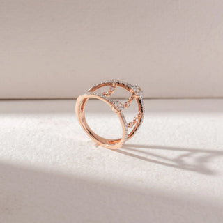 Angled view of open double-band ring in yellow gold with pavé diamonds and chain-linked diamond accents, set on a soft neutral background, highlighting layered structure and delicate sparkle.
