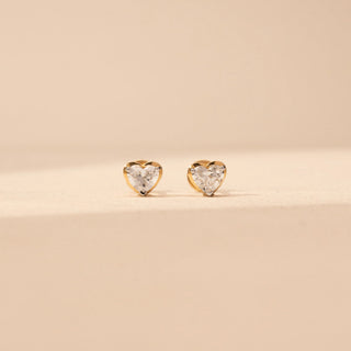 Close up vview of heart-shaped lab-grown diamond stud earrings in 14 KT White gold, featuring three-prong heart-cut solitaire diamonds in a timeless romantic design.