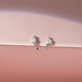 Front view of 14KT White Gold drop earrings featuring round opal gemstones, diamond accents and cascading round-shaped diamond clusters.