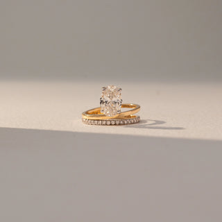 Front view of Oval Solitaire Diamond Ring with Band in 14KT Yellow Gold, featuring a centred oval lab grown diamond with a pavé band. Set on a beige backdrop, the design highlights elegance and layered brilliance.
