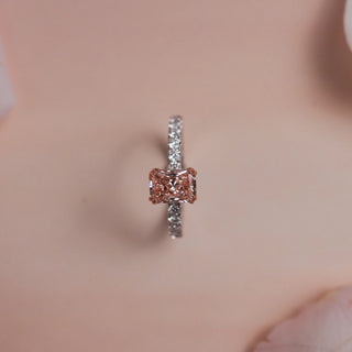 Top view of Reia Rose Glow Radiant Diamond Ring on a blush-peach background, featuring a radiant-cut blush pink lab-grown diamond with EF VVS accents on a 14KT white gold band.